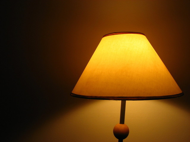 Rozsvietená stolová lampa pri stene