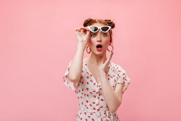 redhead-woman-midi-dress-heels-is-posing-pink-background-holding-glass-champagne_197531-14955